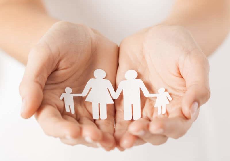 close up of womans cupped hands showing paper man family